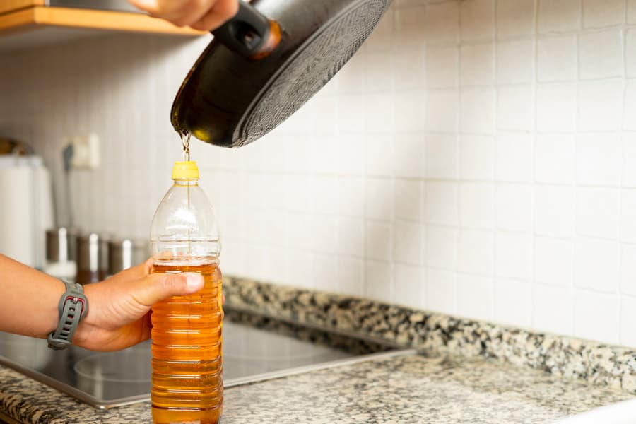 Used cooking oil being poured into a container for recycling