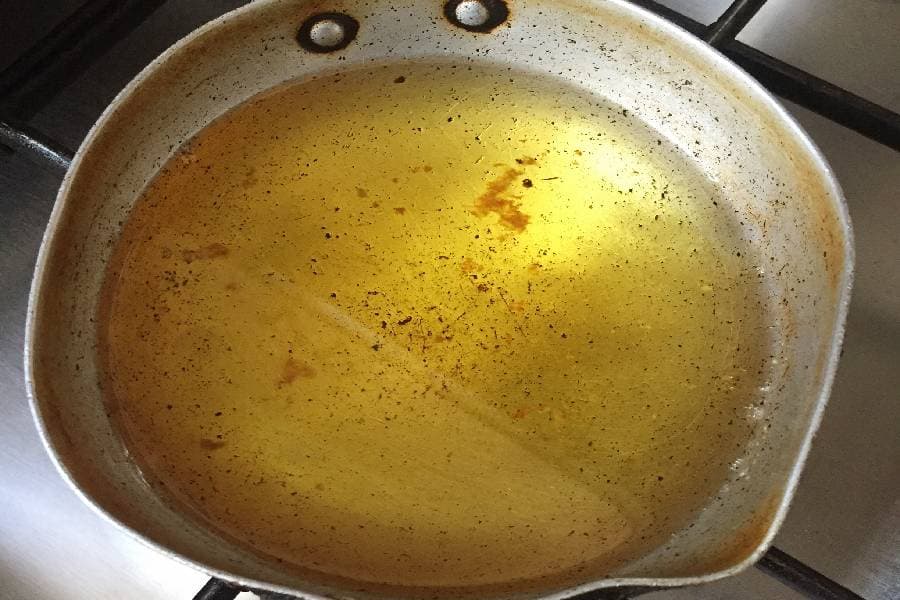 Cooking oil in large pan on commercial kitchen stovetop